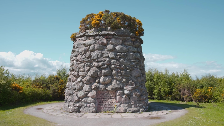 Culloden battlefield memorial cairn in Scotland on sunny day.