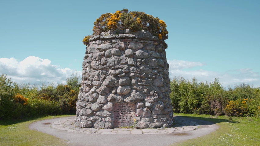 Culloden battlefield memorial cairn in Scotland on sunny day.