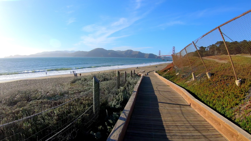 A view from the eyes of a tourist walking on Baker Beach in San Francisco. A trip to the sandy beach in the morning. Handheld shooting.