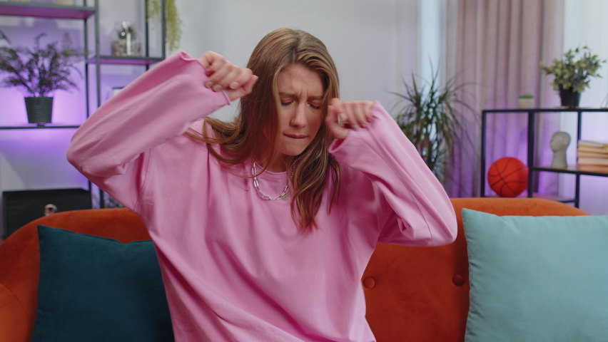 Overjoyed delighted caucasian adult girl showing rock n roll gesture by hands, cool sign, shouting yeah with crazy expression, dancing, emotionally rejoicing in success. Young woman at home apartment