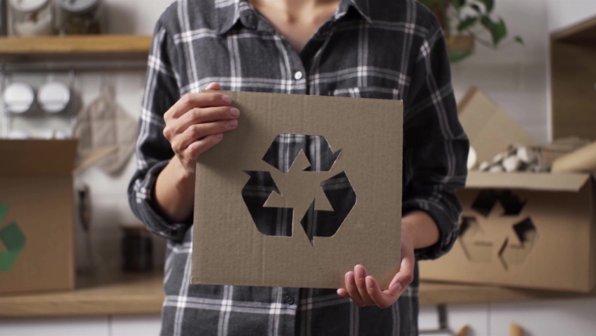 Processing of raw materials of products. A girl holding a recycling sign stands against the background of sorted materials for reuse. Sorting and recycling of disposable tableware
 Royalty-Free Stock Footage #1093935715
