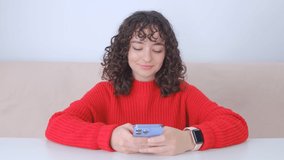 Typing sms message on mobile phone app. Young white woman communicating online on social media application in smartphone. Cheerful brunette girl texting on messenger app in cellphone in 4K stock video