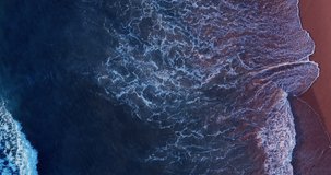 Water wave texture beach video Aerial view Top-down ocean wave Aerial video beautiful closeup shot beach and seawater on wave on sand in sunset time (Top-view) nature and travel concept video.