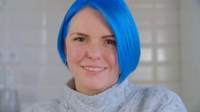Happy blue haired woman. Portrait of cheerful white female with colored hair. Royalty free stock video clip of friendly millenial person looking in camera and smiling