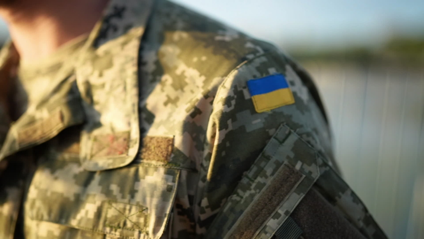 Soldier of the Ukrainian army. Chevron yellow-blue flag close-up. Shoulder of a man in military uniform, pixel. Defender of Ukraine. Slow motion. | Shutterstock HD Video #1093941817
