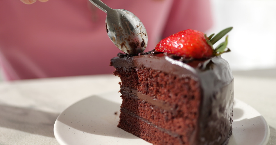 Eating chocolate cake with spoon close up shot, Taking bite of chocolate cake with strawberry, Tasty chocolate fudge cake