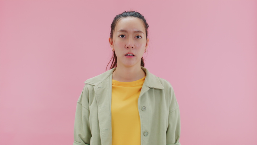 HOLDING BREATH, Frustrated attractive young asian woman looking at camera closing grabbing nose pinching with fingers avoid stinky bad smell feeling disgusted unpleasant.Isolated on Pink Background | Shutterstock HD Video #1093943783