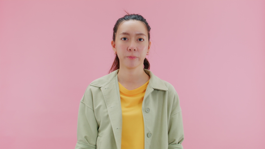 NO WAY, serious young asian woman showing STOP hand gesture looking at camera. Displeased attractive girl shows warning sign with crossed hands, no way, deny rejected .Isolated on Pink Background Royalty-Free Stock Footage #1093943865