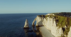 Panoramic view of the picturesque rocky mountains with a natural arch and a chalk peak sticking out of the water separately, on the banks of the English Channel. Etretat, France. 4k video, red komodo