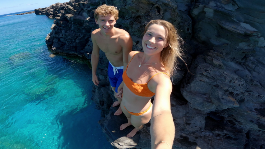 POV Young happy couple cliff jumping into tropical blue ocean Royalty-Free Stock Footage #1093949195