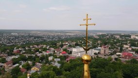 Golden cross on the roof of the church. View from a height. Panorama of the city. Kazan Cathedral Stavropol