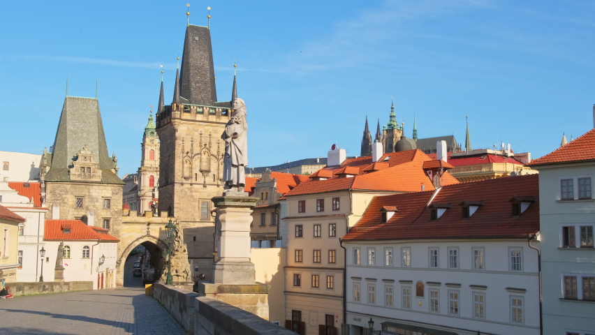 Charles Bridge with historic statues, Lesser Town Bridge Tower and the tower of the Judith Bridge at sunny day in Prague, Czech Republic. Famous Karlov most bridge without people. Steadicam shot