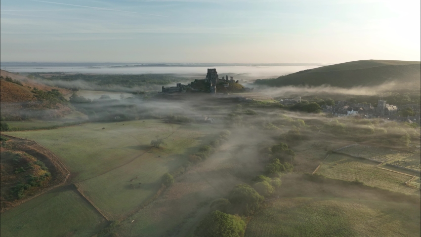 View of Corfe Castle and surrounding countryside on a misty morning, Dorset, UK.