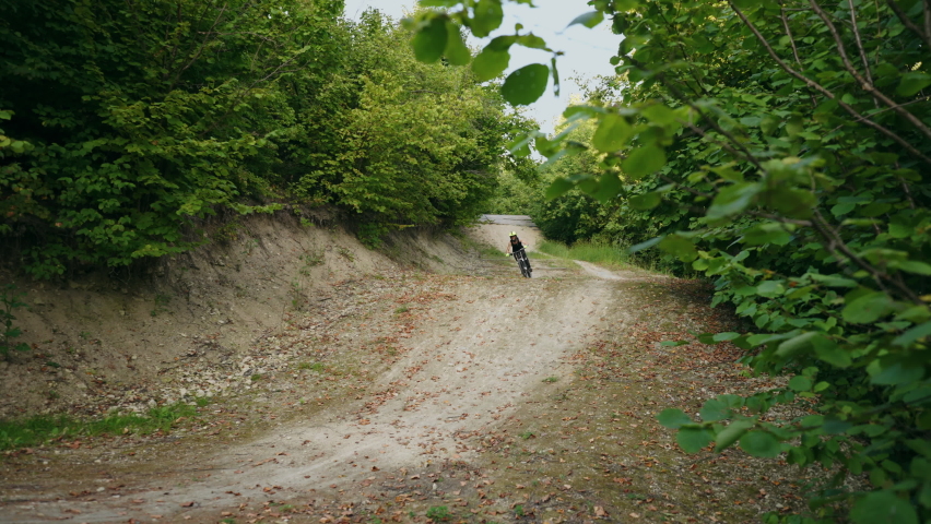 ride bicycle extremely, young sporty man is riding  bike, jumping on road and flying above ground