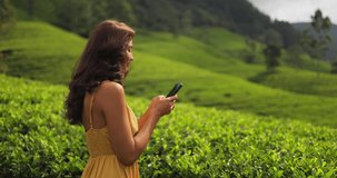 Romantic vlogger traveler woman sharing photos and videos with mobile phone app her travel vacation to famous nature landmark tea plantations in Sri Lanka. Gen Z talent happy girl influencer making