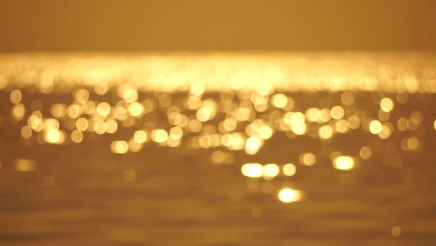 Abstract nature summer ocean sunset sea background. Small waves on water surface in motion blur with bokeh lights from sunrise. Holiday, vacation and recreational background concept. Slow motion | Shutterstock HD Video #1093992831