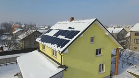 Aerial view of snow melting from covered solar photovoltaic panels installed on house rooftop for producing clean electrical energy. Low effectivity of renewable electricity in nothern region winter - Powered by Shutterstock - Get 15% off with code: PIKWIZARD15