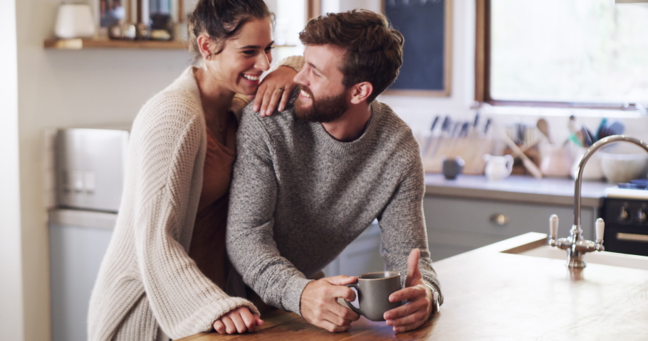 Happy, love and funny couple with coffee, morning tea or drink bonding in home kitchen together. Portrait of smile, playful people or comfort man and relax woman in house room, hotel or accommodation Royalty-Free Stock Footage #1094020559