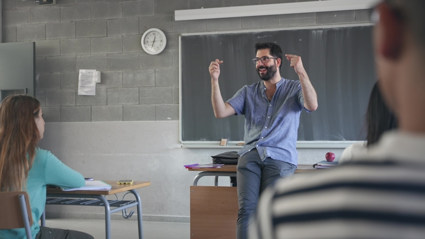 Young passionate teacher with beard and eyeglasses explaining lesson to students in the school Royalty-Free Stock Footage #1094021297
