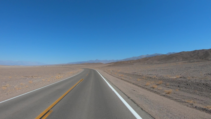 TRAVELING CAR - Drive through Death Valley National Park in California, USA. Desert road in Death Valley.