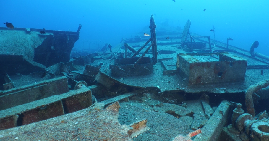 fish group aroud shipwreck scenery underwater ship wreck deep blue water ocean scenery of metal underwater 