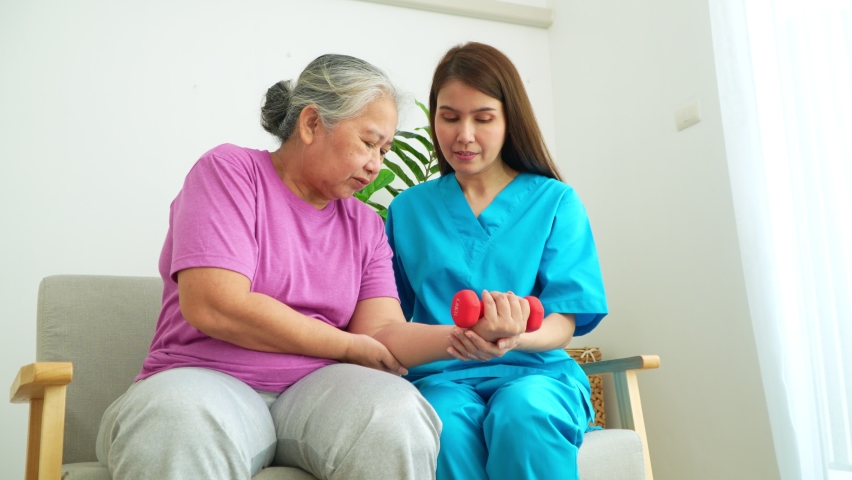 Asian Caregiver nurse doing physical therapy assistance and support teach body and muscle exercises to elderly women. Physical therapy and senior citizens rehabilitation concept. Royalty-Free Stock Footage #1094040693