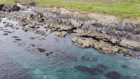 Rocky seashore on a sunny day. Picturesque seascape. Beautiful coastline. Aerial view, video in full hd format.