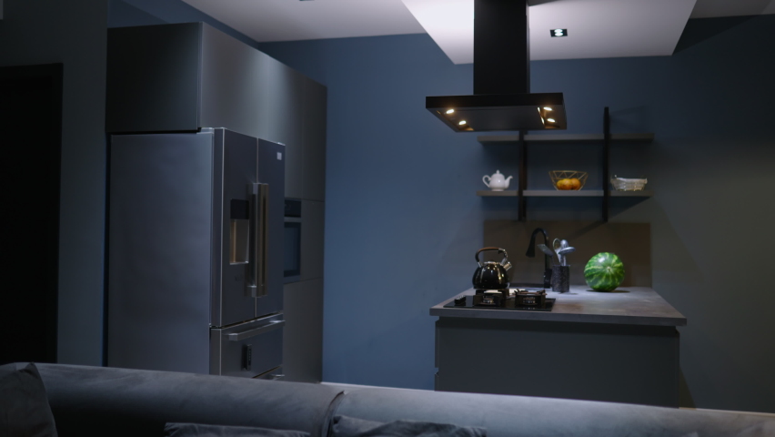 Young woman takes a chocolate pie out of the oven. Girl makes pastry at home. Female performs homemade baking in a stylish modern kitchen. Housewife preparing food on a kitchen island.