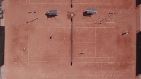 Large tennis court taking video with drone two professional team have a match they hitting the ball and catch very professional concept of sport and healthy lifestyle