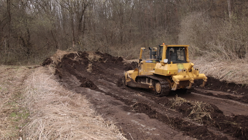Construction machinery equipment, earth building bulldozer, earthmoving machine technology, industrial erection concept. Bulldozer working on mud at a construction site