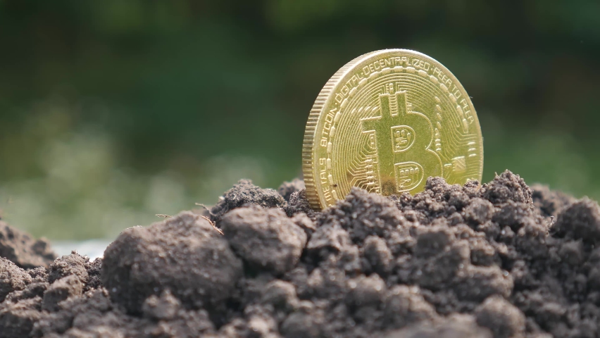 The concept of extraction and mining of cryptocurrency. Bitcoin dug up in the ground | Shutterstock HD Video #1094049743
