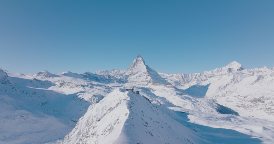 Aerial drone flyover Gornergrat with Matterhorn view during winter in Switzerland. Majestic mountain peaks iconic famous zermatt travel ski resort in the alps. Wonderful inspiring nature landscape. Royalty-Free Stock Footage #1094050583