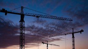High crane works on building site with a house. silhouettes of construction cranes. - Powered by Shutterstock - Get 15% off with code: PIKWIZARD15