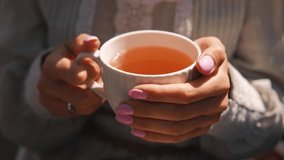 close up video of woman holding hot cup of tea outdoors during autumn