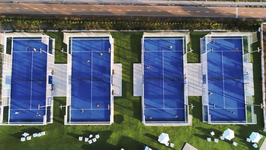 Overhead top view zoom in aerial shot of a blue Padel field in a sport centre in the city. Sport. Four players are playing together. Royalty-Free Stock Footage #1094069421