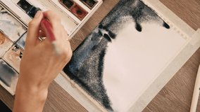 Close up video of woman painting with watercolors