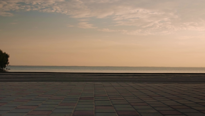 Young woman doing backflips.Girl doing acrobatic activity against the sea at sunrise. Fitness Lifestyle slow motion. High quality 4k footage