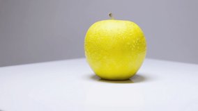 One tasty wet ripe yellow apple turning shows all sides with endless motion