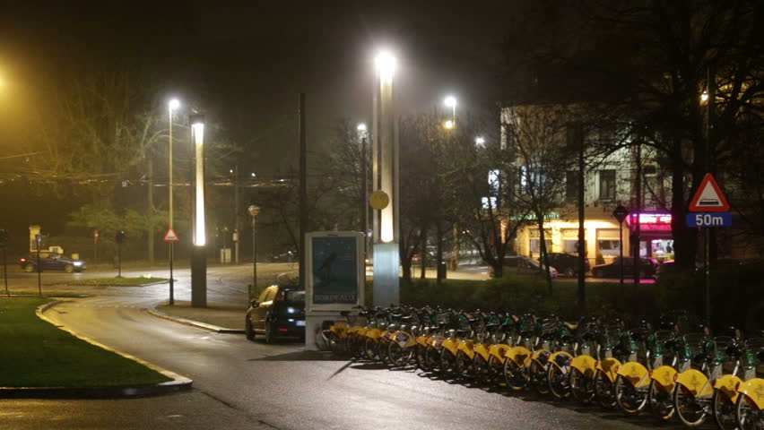 Night street after rain with passing traffic near Atomium, Brussels