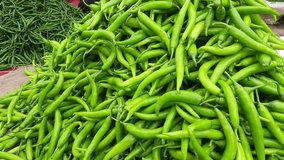 Close-up top view of freshly harvested green chilies, and capsicum, displayed in the weekly market for sale in Maharashtra India.