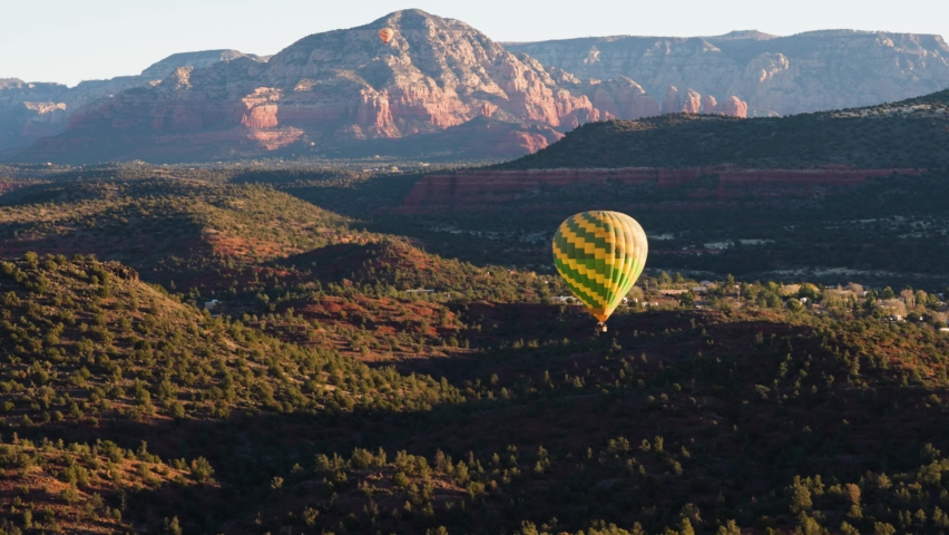 Hot air balloon floats over scenic Coconino National Forest, Sedona, Arizona