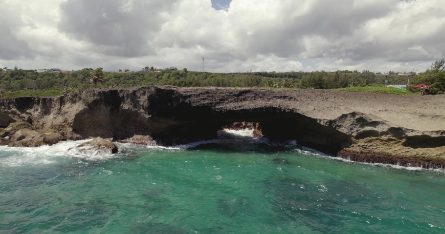 Aerial view around a rocky Pozo de Jacinto sea arch on the coast of Isabela, Puerto Rico, USA