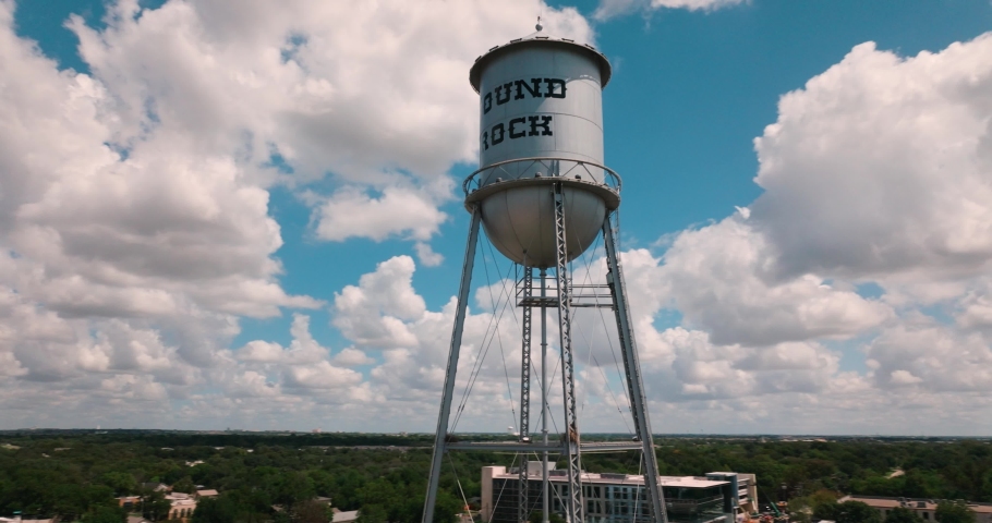 Downtown Round Rock Water Tower Aerial rise up around tower on sunny summer day in 4k