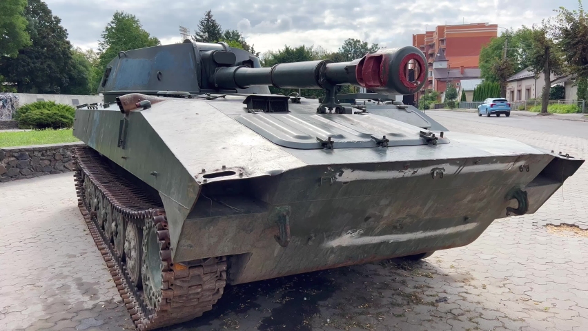 A tracked self-propelled military howitzer stands on a city street. Russian artillery howitzer. A destroyed Russian howitzer during the war in Ukraine.