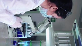 Vertical Video, Female Microbiologist Looking into Microscope in Medical Science Laboratory. Scientist, Working with High-Tech Equipment. Pharmaceutical Medicine, Biochemistry, Science Concept.