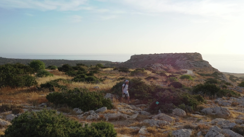 Summer landscape in Cyprus. View from the top of Cape Greco. Morning sunrise in Cyprus. A man walking on top of a cliff