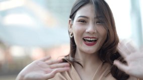 Teenager Asian woman feeling happy smiling and looking to camera while relax at outdoor city. Portrait of successful business woman talking to camera. Happy feeling concept.
