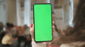 Handheld Camera: Point of View of Woman at conference room Using Phone With Green Mock-up Screen Chroma Key Surfing Internet Watching Content Videos Blogs Tapping on Center Screen
