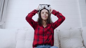 Young woman with a virtual reality headset playing a game at home
