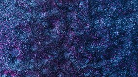 Vertical video. Shimmering texture. Glitter bubbles. Sparkling fluid splash. Fluorescent blue pink color shiny liquid blend abstract background. Shot on RED Cinema camera.